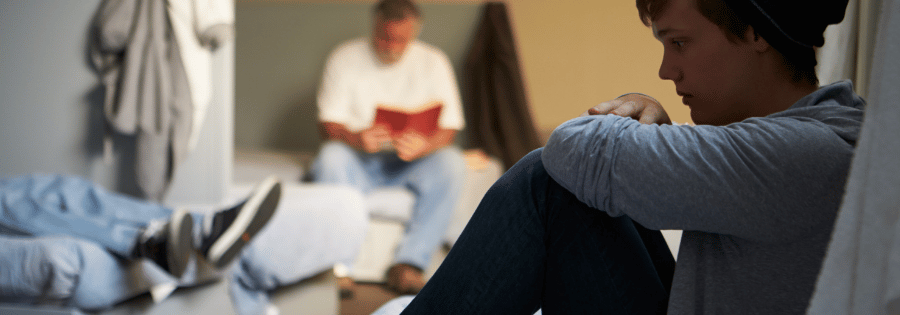 Boy sat alone on a bed