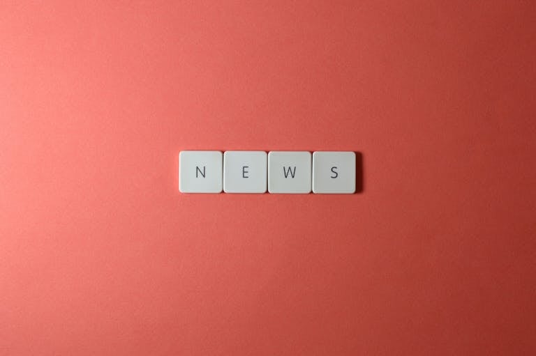 Close-up of keyboard keys spelling 'NEWS' on a red background, minimalist style.